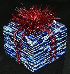 holiday present wrapped in blue stripey wrapping paper with a red sparkly bow