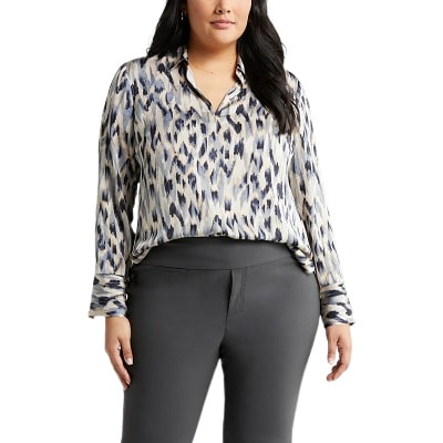 A woman wearing a print blouse and gray pants