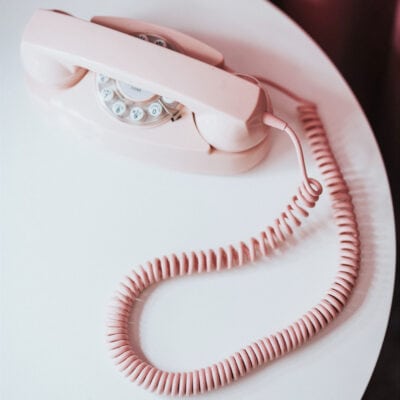 pink rotary phone sits on table