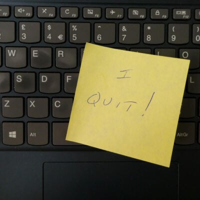 black keyboard with yellow post-it note on it that reads "I QUIT!"