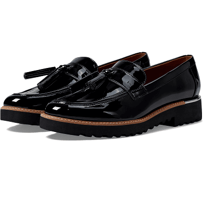 black patent loafers with large tassle, lug soles, and a brown strip running around the sole