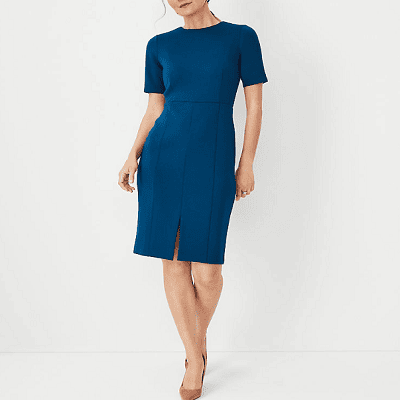 A woman wearing a blue sheath dress