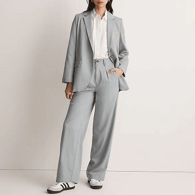 young professional woman wears drapey gray suit with sneakers